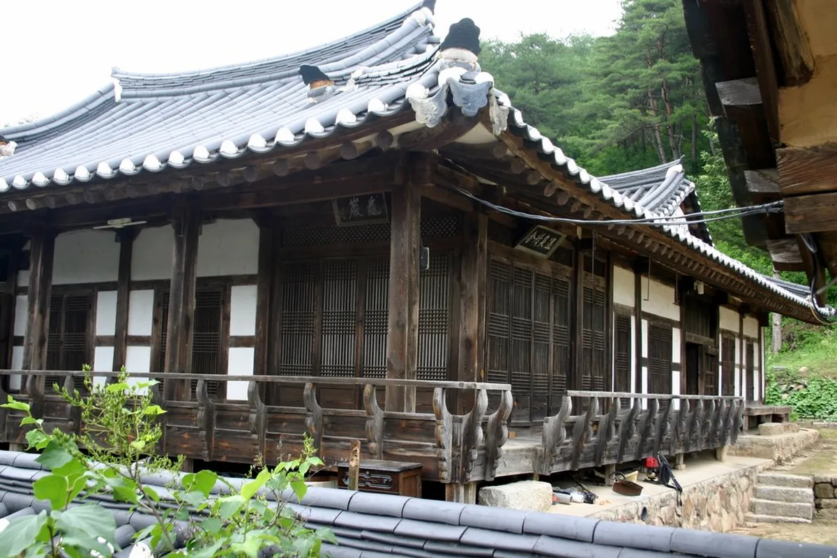 Traditional wooden hanok house with a tiled roof and latticed sliding doors in Andong