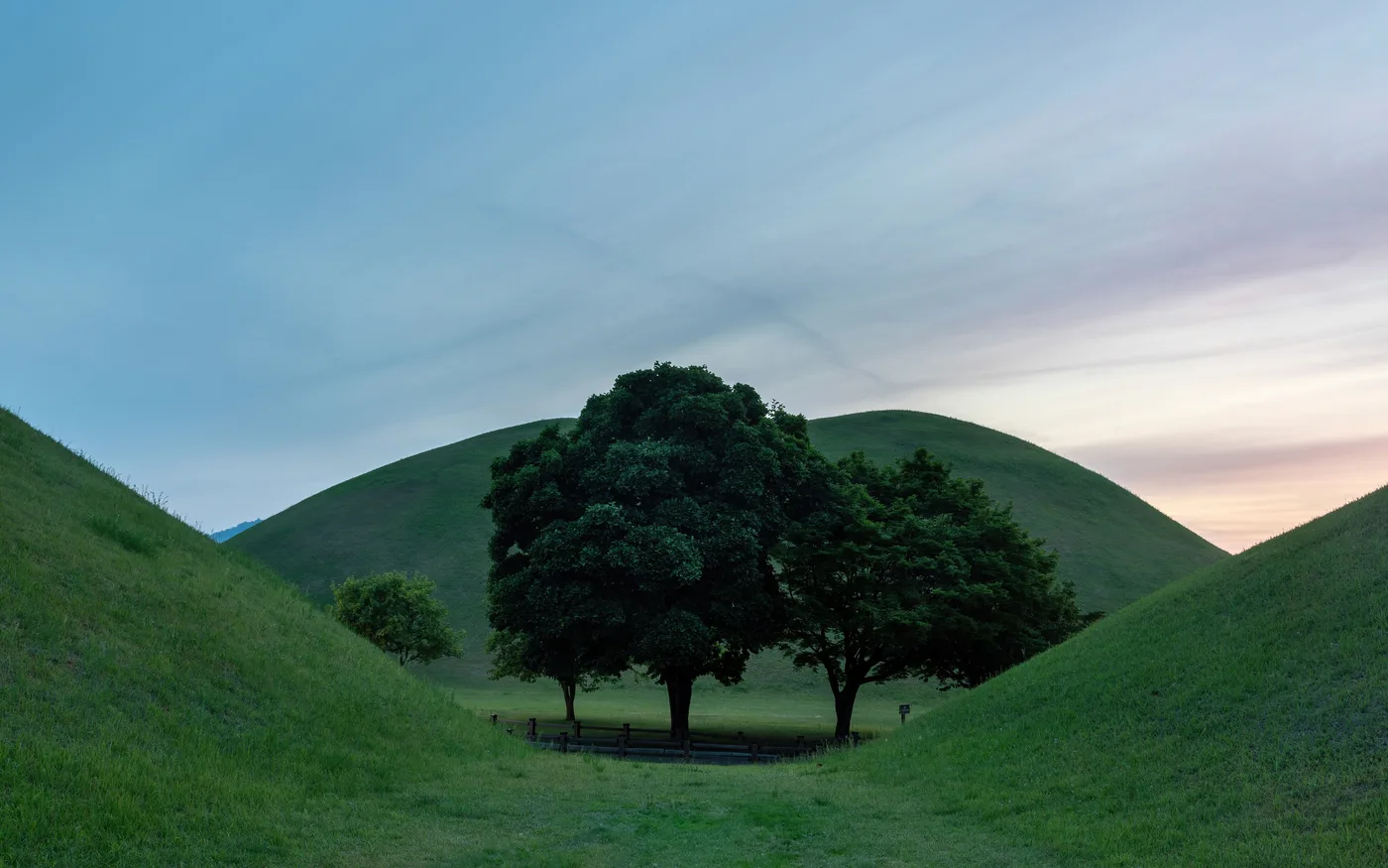 Grassy burial mounds of Silla-era royal tombs at Daereungwon tomb park in Gyeongju at dusk