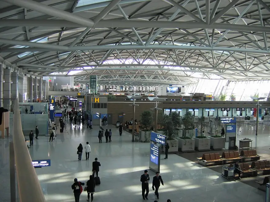 Departure hall at Incheon International Airport with travelers walking toward the gates