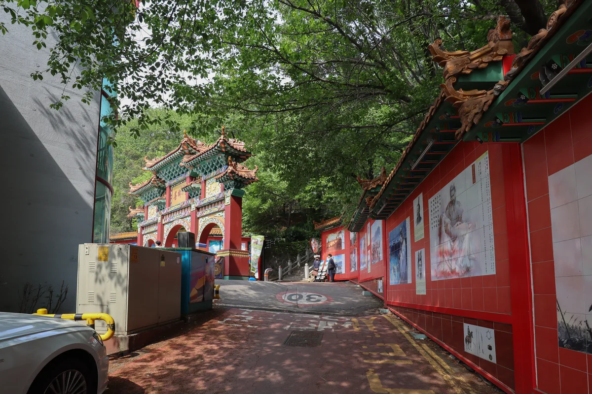 Incheon Chinatown Ornate red and gold traditional Chinese gate at the entrance to Incheon Chinatown, with murals lining a street beside it
