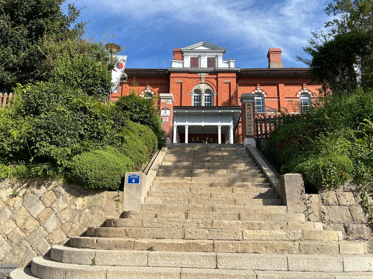 Red-brick colonial-era building of the Mokpo Modern History Museum, Hall 1, viewed from a stone staircase