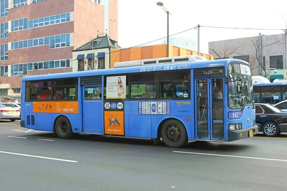Blue trunk-route city bus in Seoul traffic
