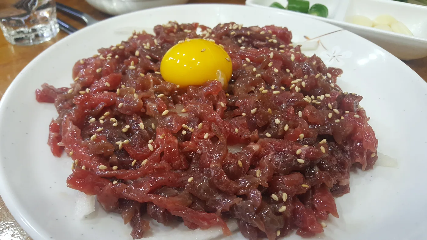 Yukhoe at Gwangjang Market A plate of yukhoe, Korean raw beef tartare topped with a raw egg yolk and sesame seeds, served at Gwangjang Market